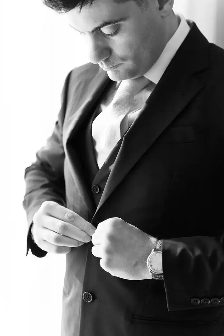 The groom fastening his cufflinks, portrait in black and white